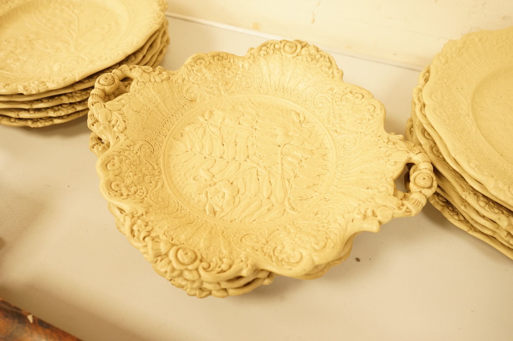 A Victorian drabware part dessert set, comprising eleven plates and three two handled dishes, dishes 25cm wide